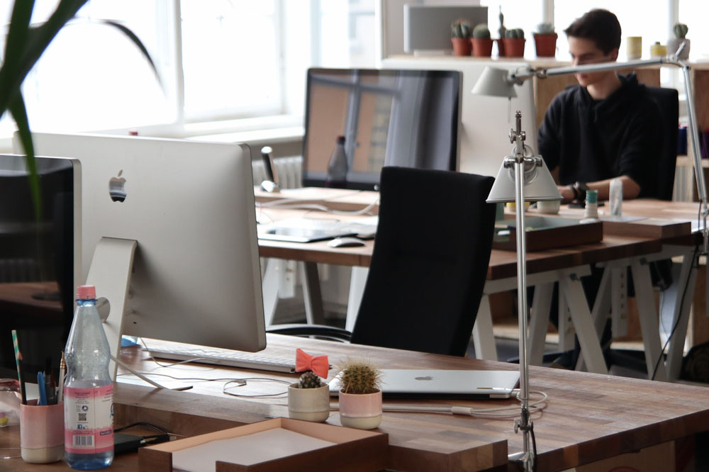 A modern office space showcasing multiple desks with computers and a bright, organized work environment